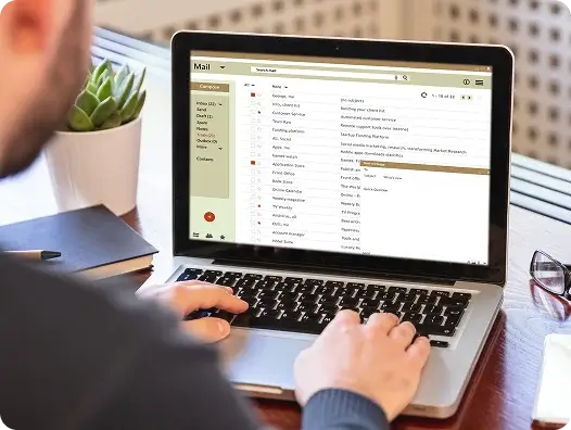A man at a computer is browsing through his mail