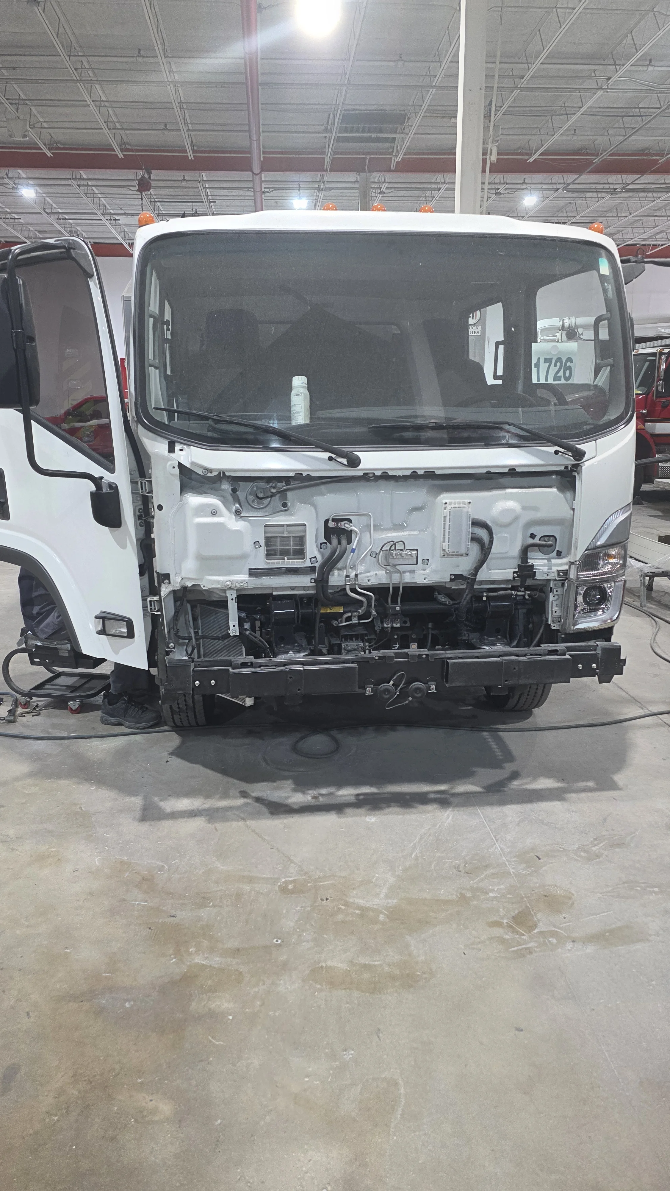 Isuzu truck cab with front body panels removed for repair in Pompano Beach, FL