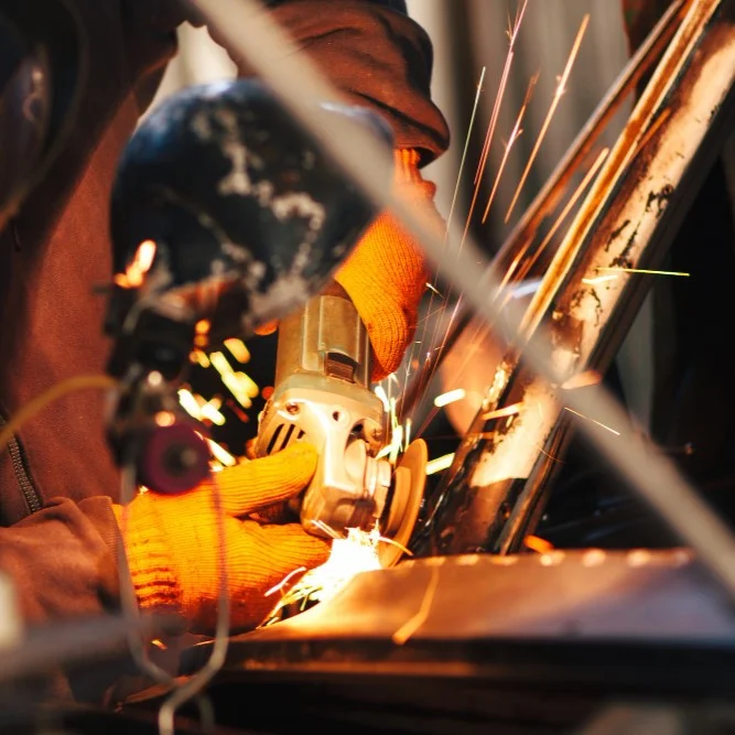 Worker cutting metal during truck repair