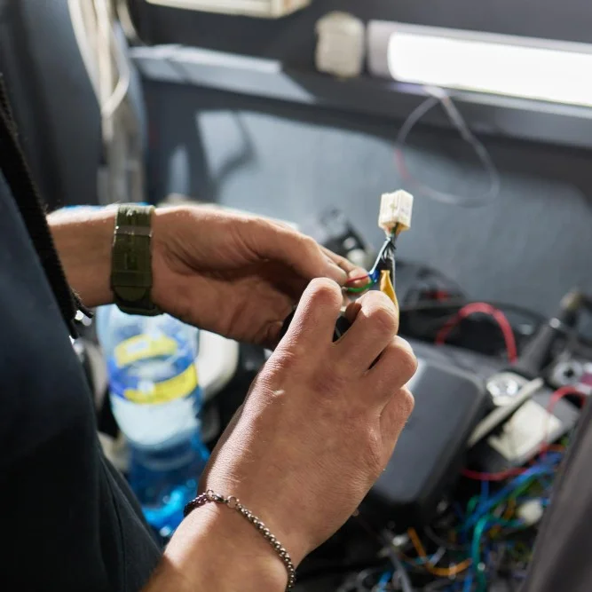 Mechanic connecting electrical wires inside truck