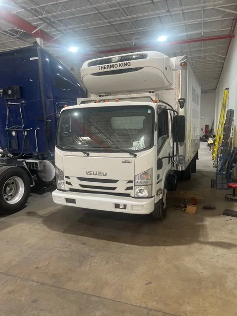 Isuzu refrigerated box truck at a repair facility in Pompano Beach, FL