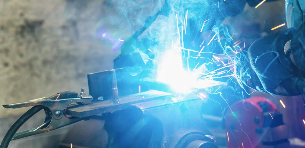 Welder fabricating custom metal bracket close-up