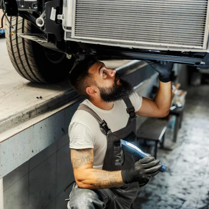 A mechanic repairs a radiator
