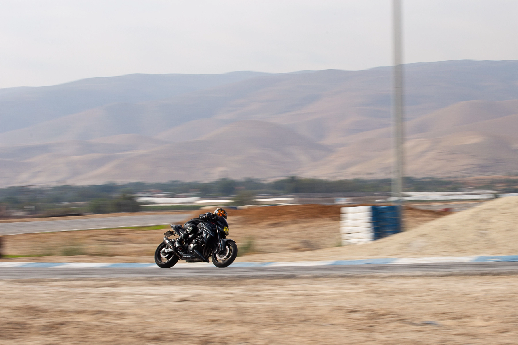 A motorcyclist speeding on a racetrack, with blurred background showing motion. Petzael, Israel