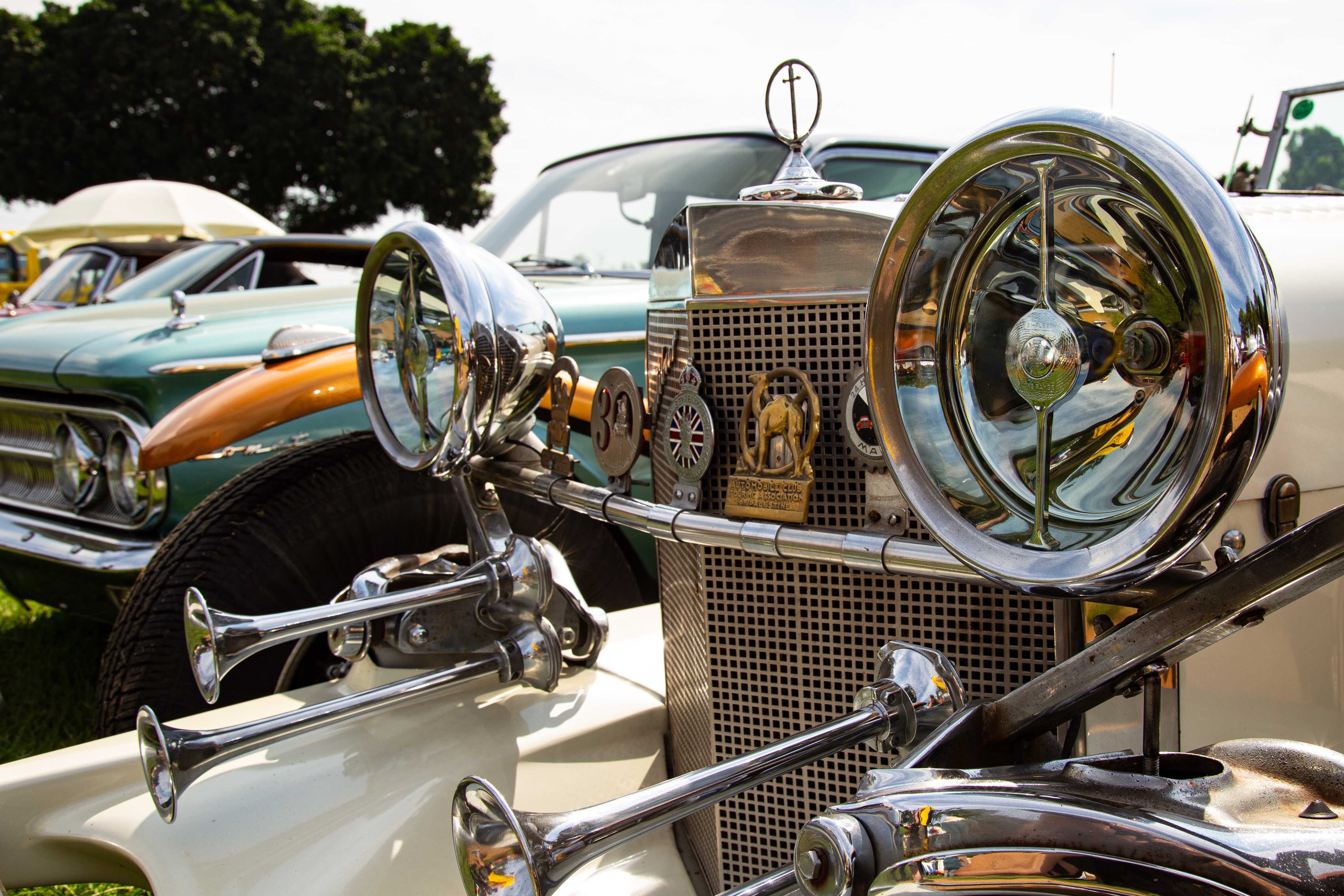 A close-up shot of vintage retro cars, featuring a classic vehicle’s chrome headlights and grille. Retro Car Club Leumi, Tel Aviv, Israel