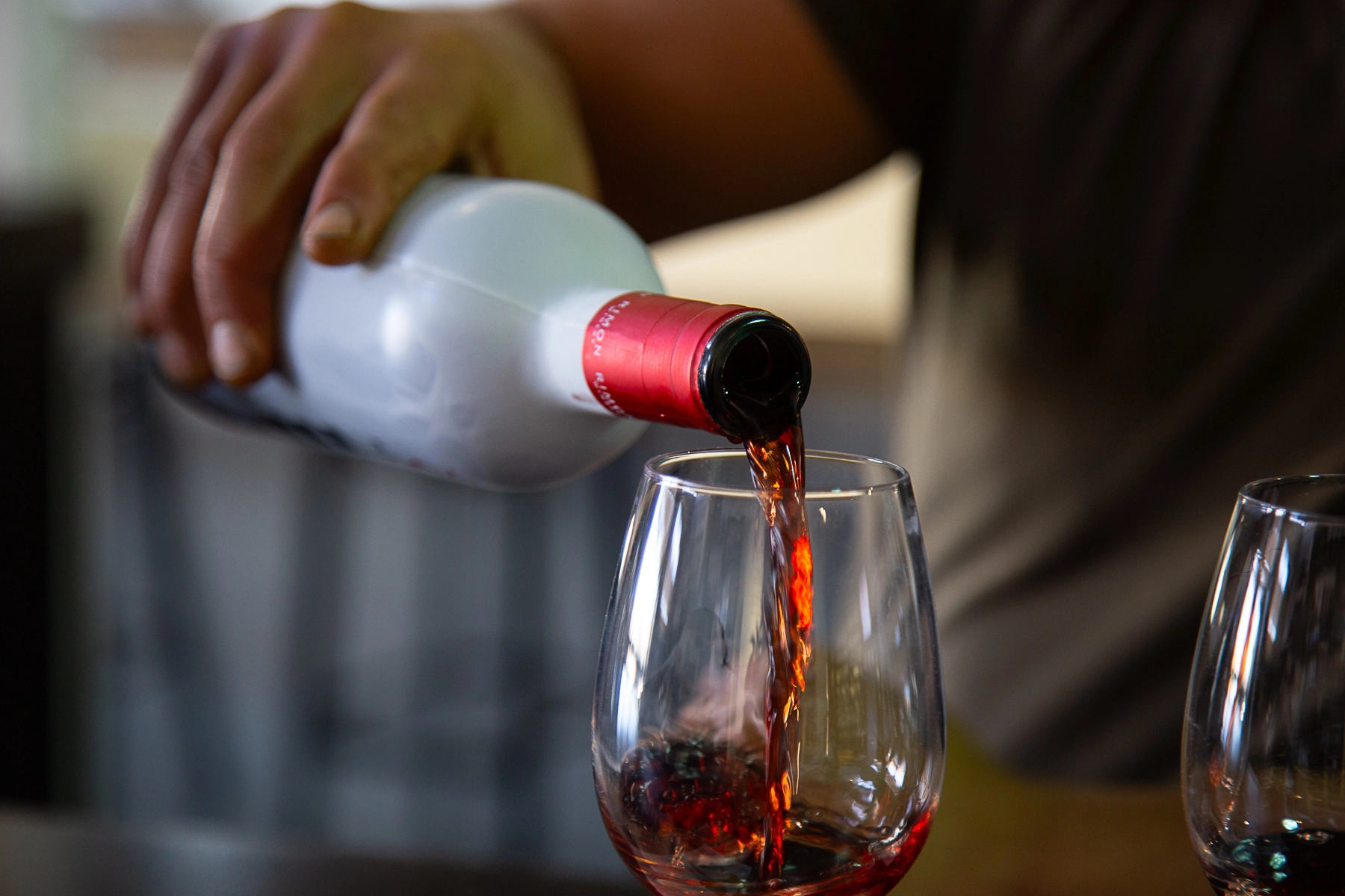 A close-up of red wine being poured into a glass from a bottle. Rimon Winery, Israel