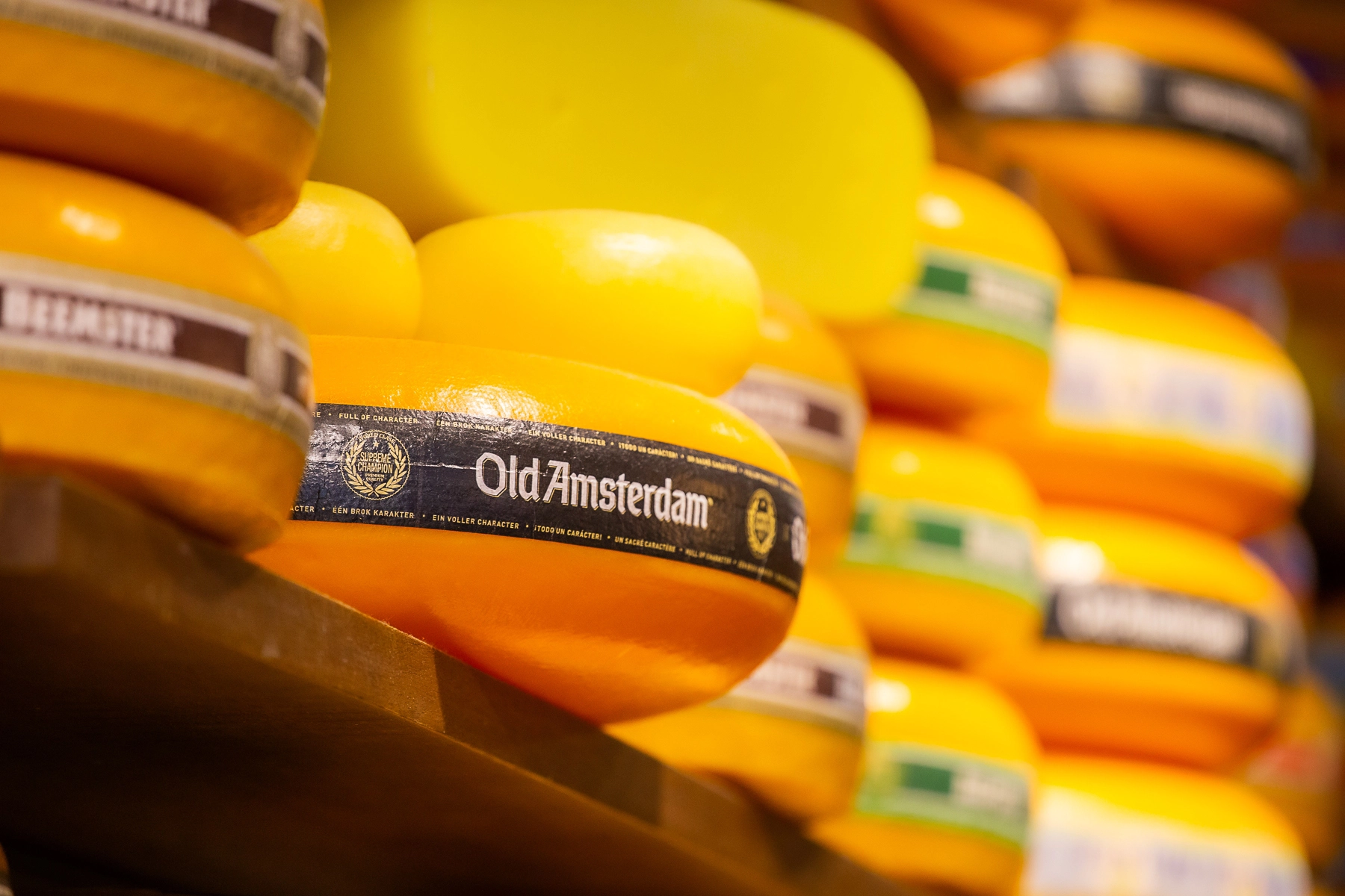 Close-up of a stack of Old Amsterdam cheese wheels displayed on a shelf.Tel Aviv, Israel