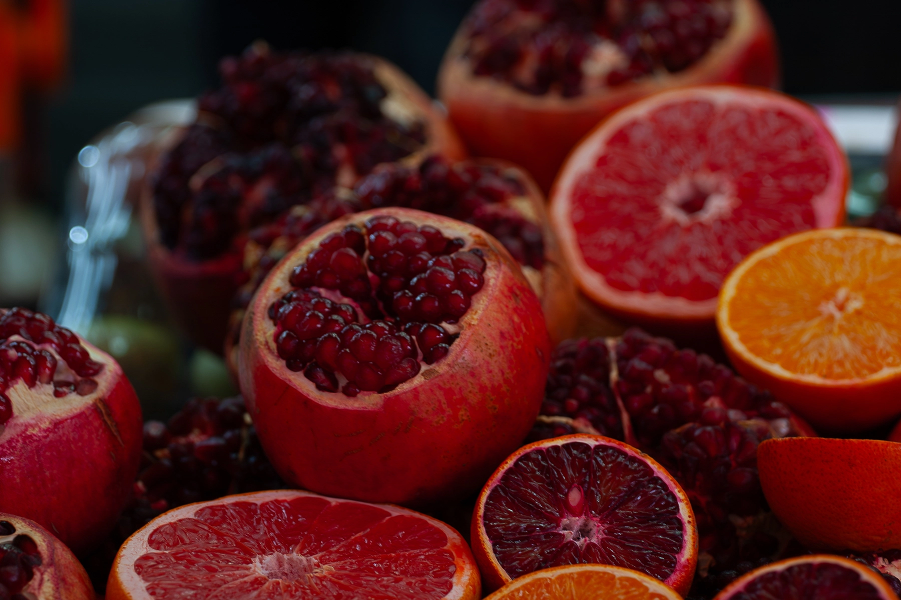 A vibrant display of halved pomegranates and various citrus fruits at a market.Tel Aviv, Israel