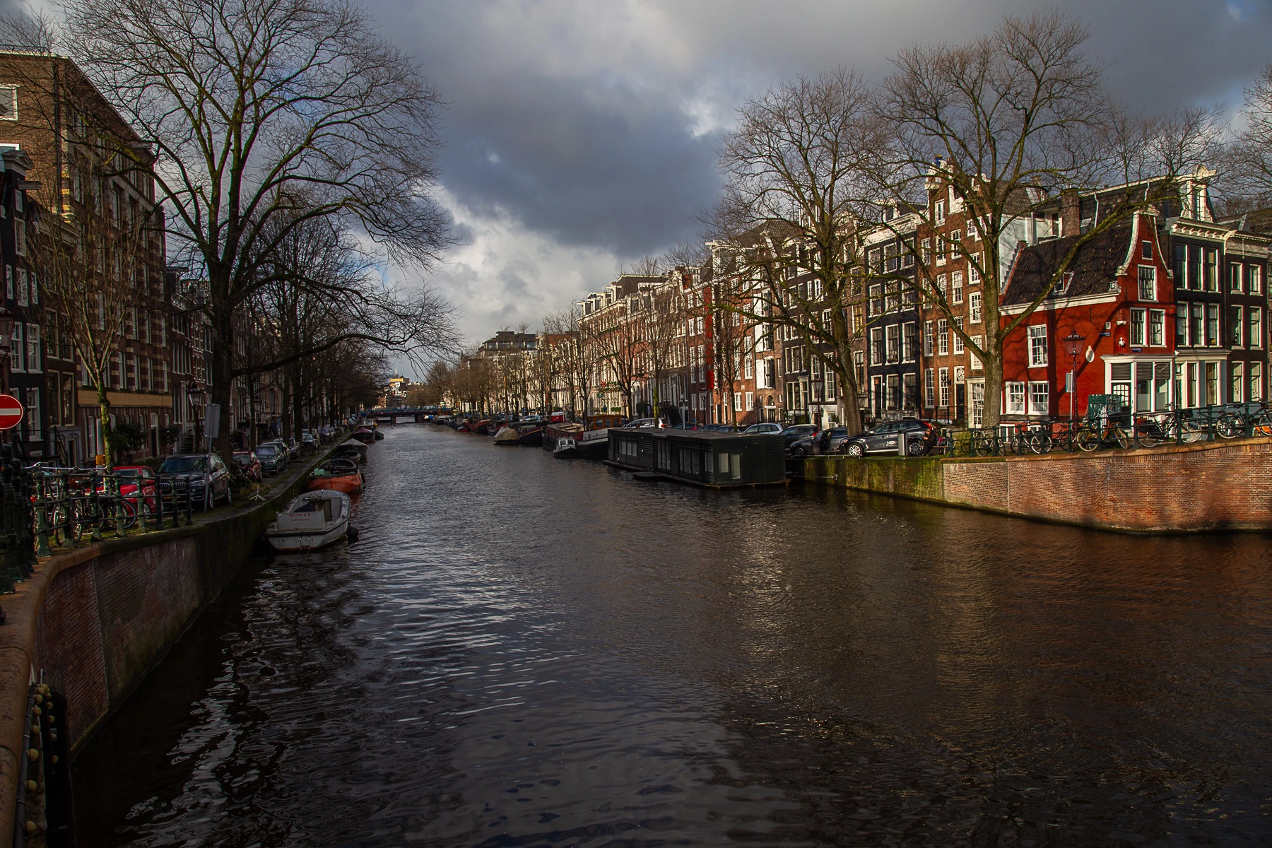 A picturesque view of a canal in Amsterdam, with houseboats and buildings lining the water. Amsterdam,Netherlands