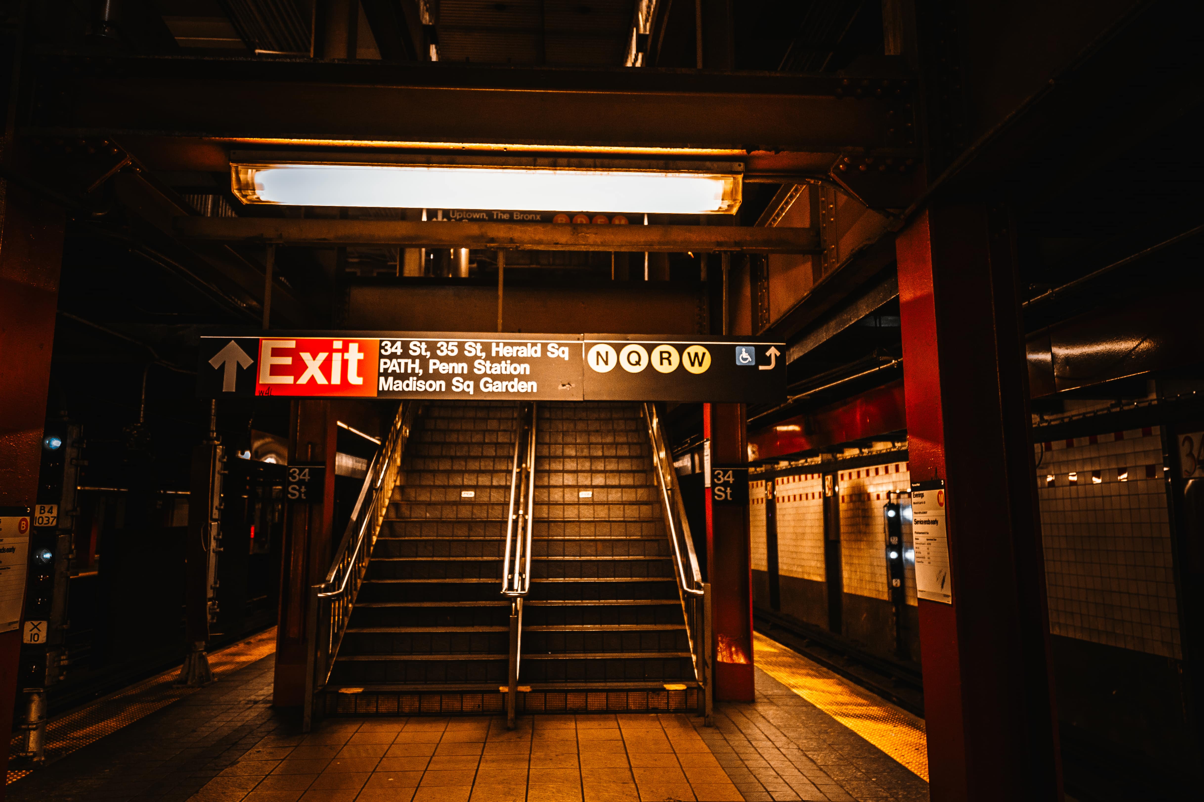 A staircase framed by tiles and beams draws the viewer toward the energy of NYC, capturing a quiet moment before the bustle beyond. 34th Street Subway Station, New York City