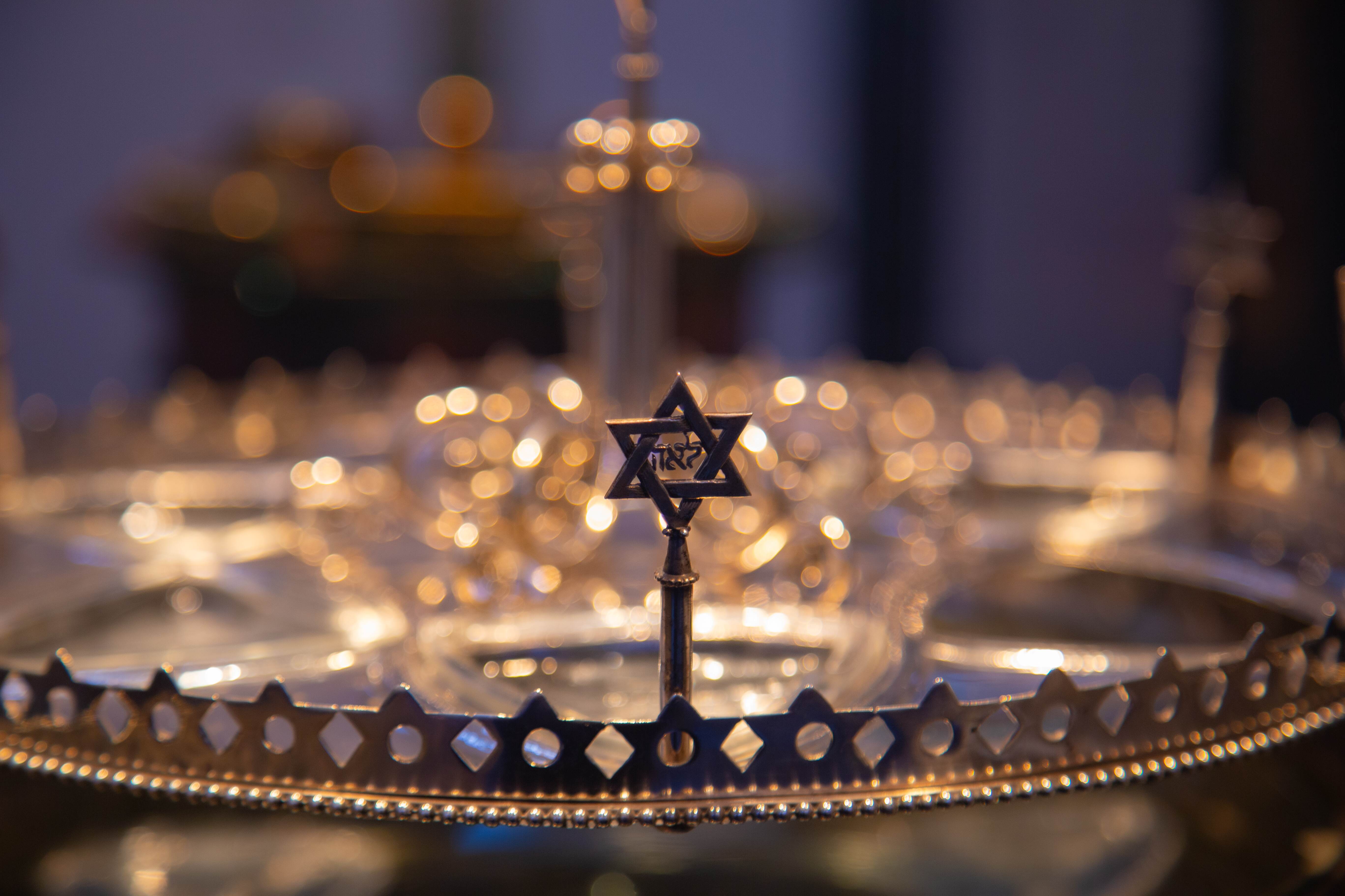 A close-up of a Star of David ornament with warm lighting and blurred bokeh background, creating a reflective mood. Museum of Israel Jerusalem, Israel