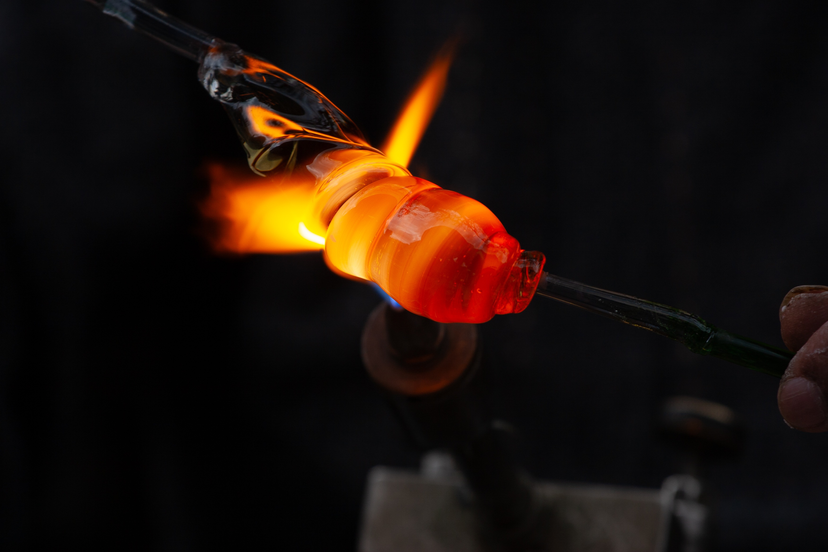 This photograph captures the delicate process of glassblowing. The flame flickers vividly, highlighting the fluidity and transformation of the glass as it morphs into a work of art. The scene evokes a sense of both fragility and power, showcasing the beauty of craftsmanship and the mesmerizing dance between fire and glass. Tel Aviv, Israel