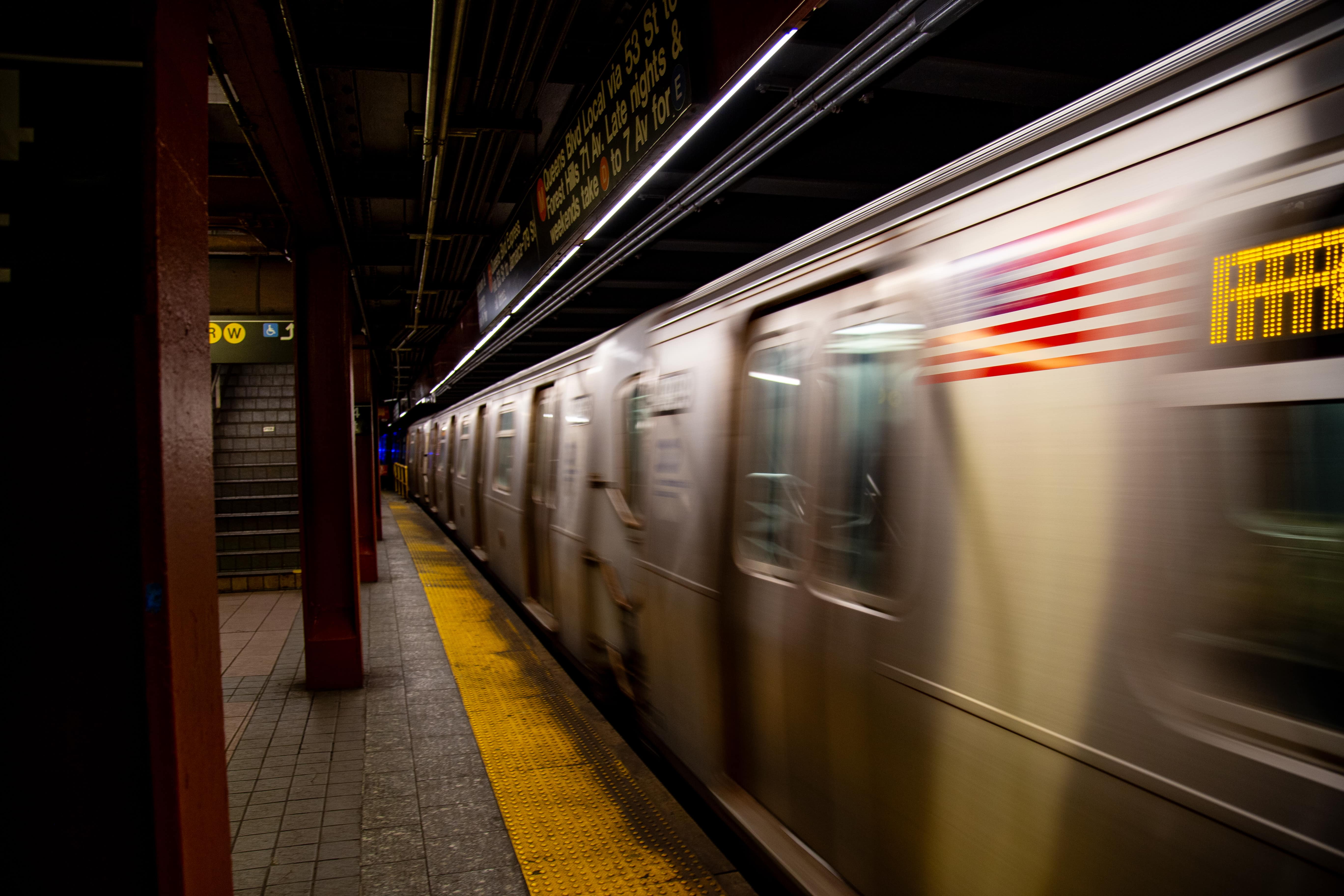 The blur of a subway contrasts with a still, empty platform, capturing the fleeting momentum of the urban commute in glowing lights and signage. 34th Street Subway Station, New York City