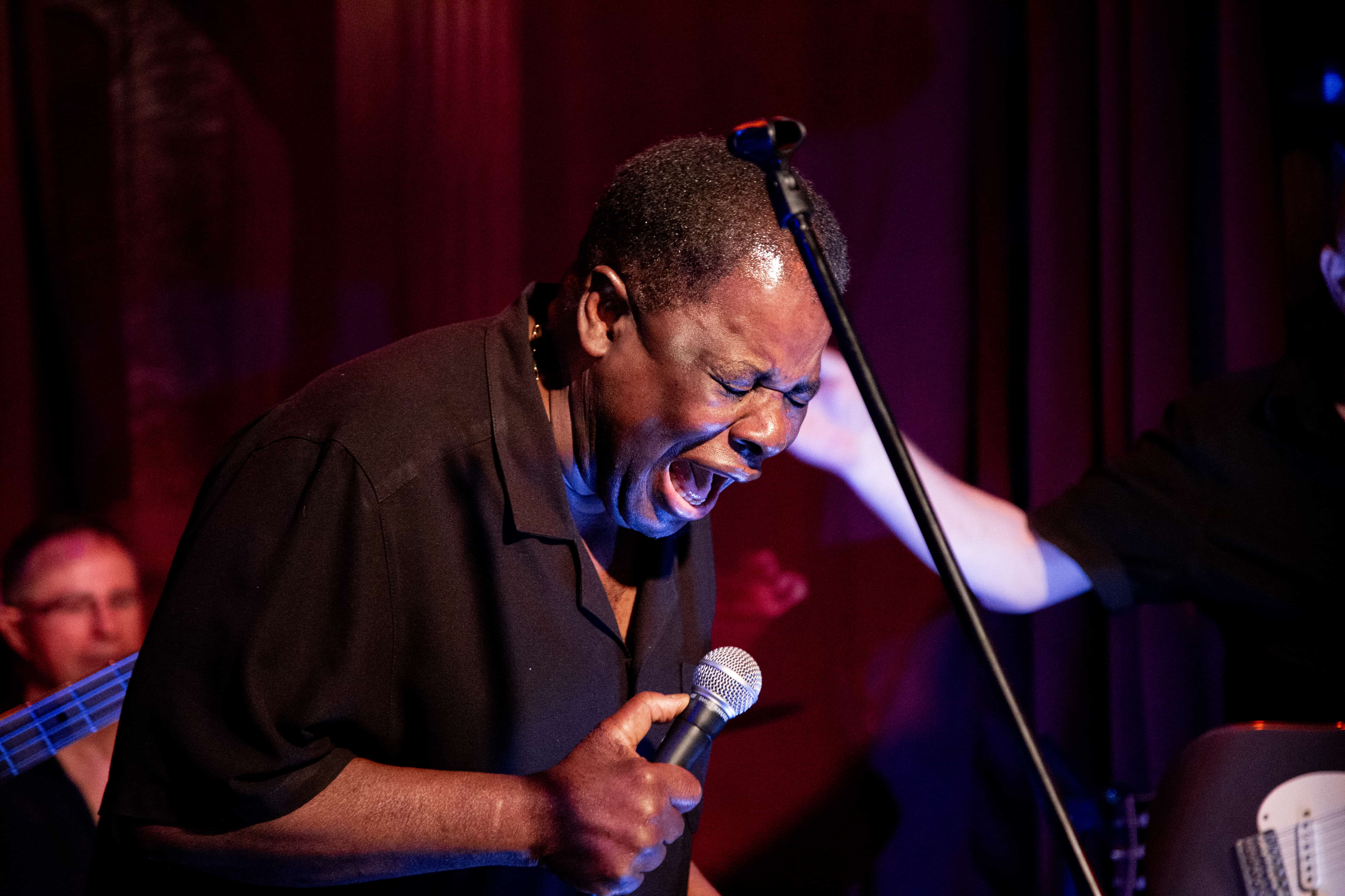 Blues performer, ,passionately singing into a microphone during a live concert. Tel Aviv, Israel