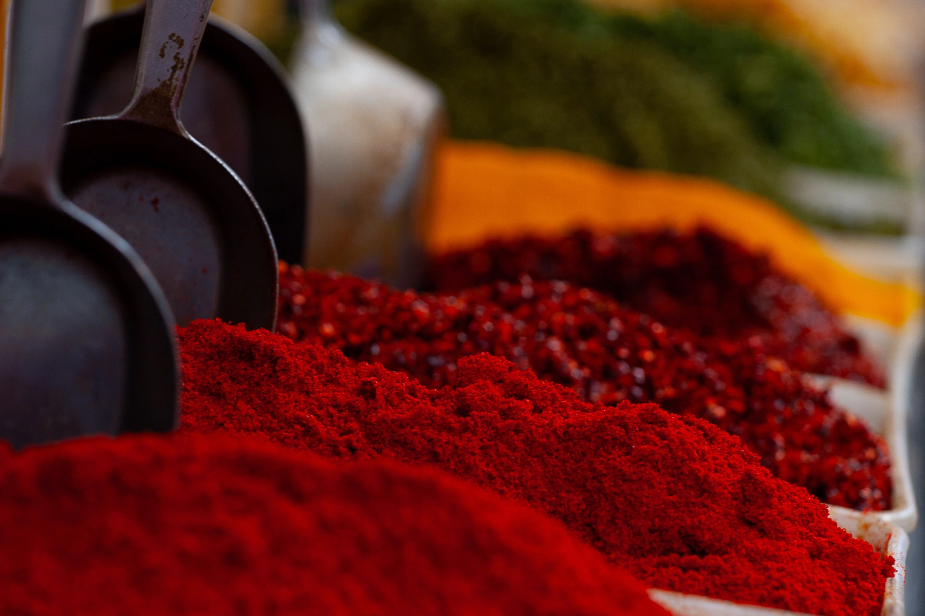 A vibrant assortment of colorful spices, including red chili powder, at a market.Carmel Market, Tel Aviv, Israel