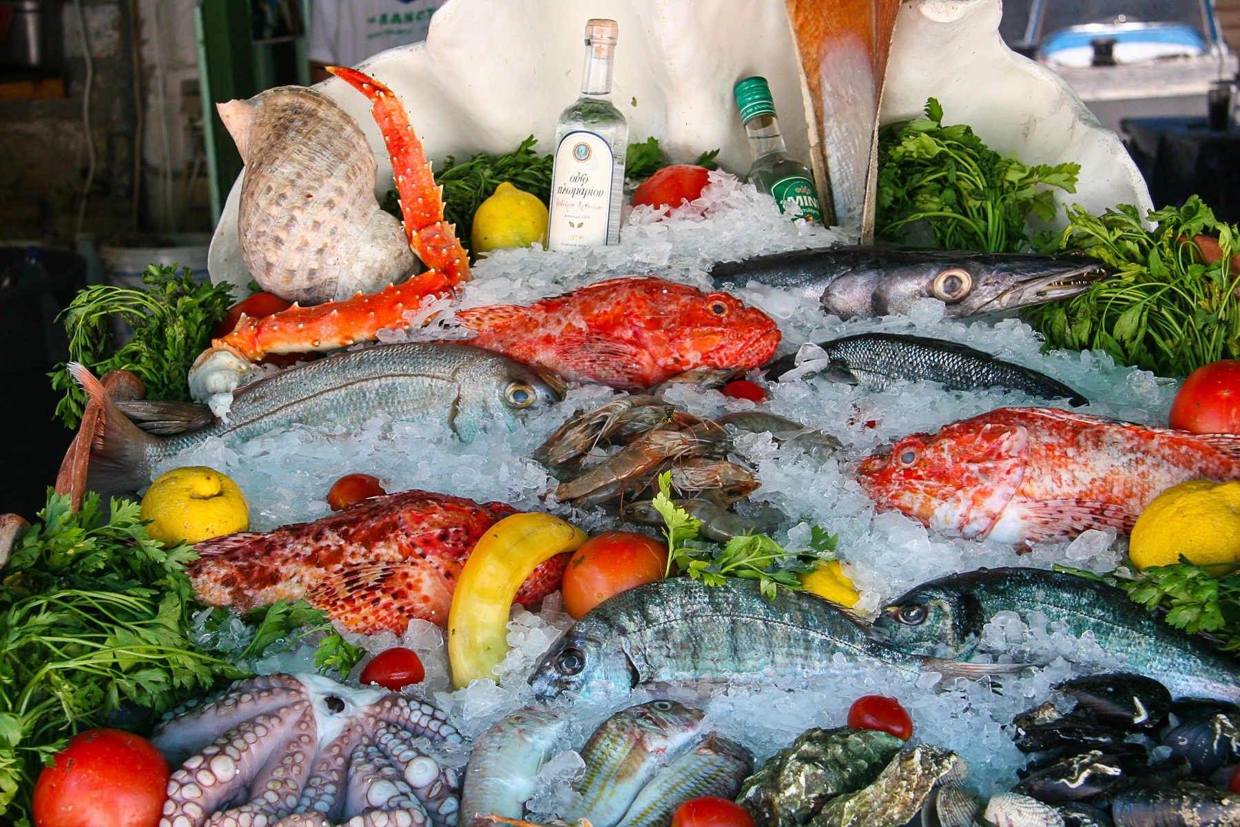 A vibrant seafood display featuring fish, crab, octopus, and garnishes on ice. Symi , Greece