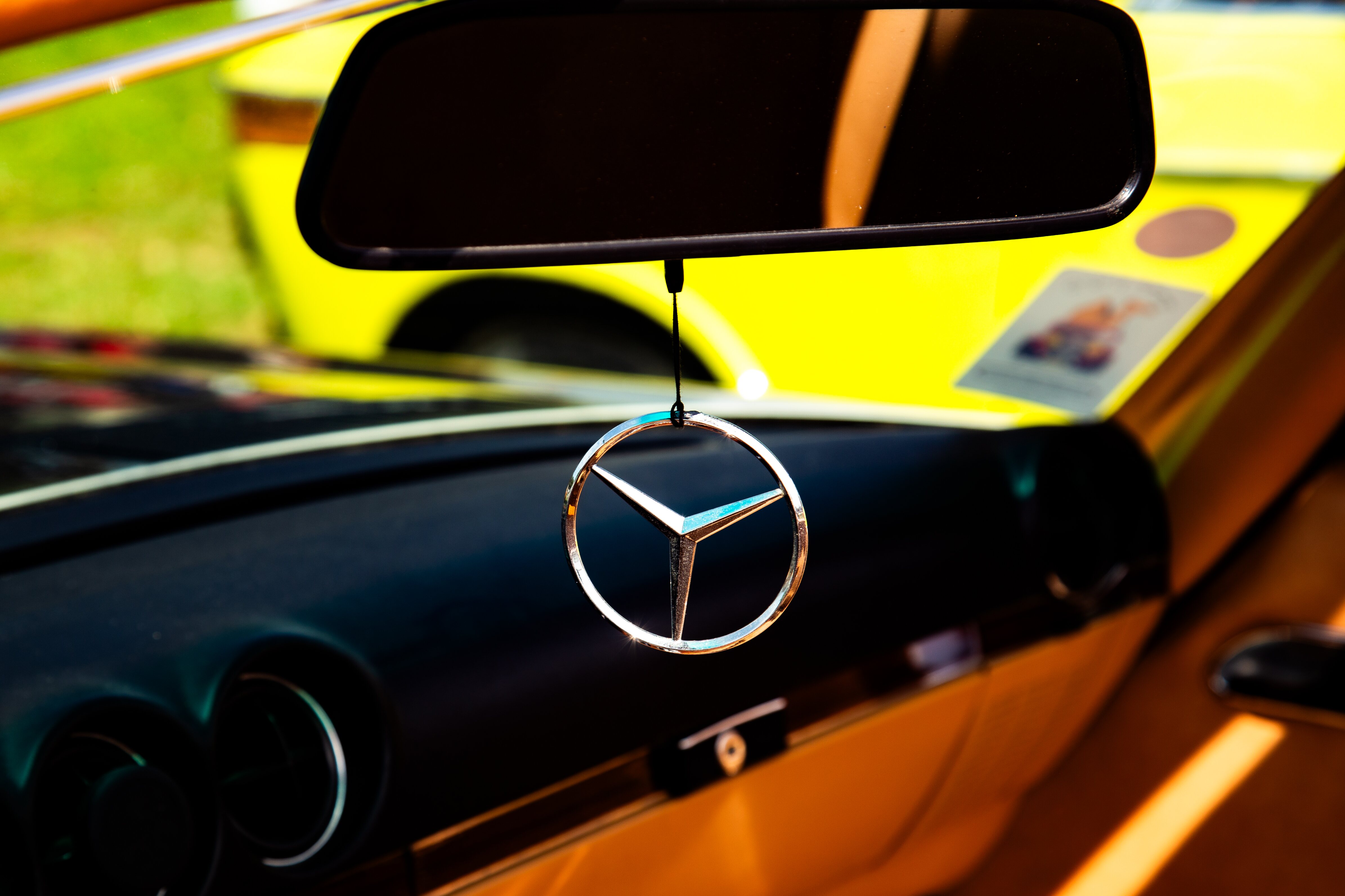 A Mercedes emblem hanging from the rearview mirror inside a vintage car. Retro Car Club Leumi, Tel Aviv, Israel