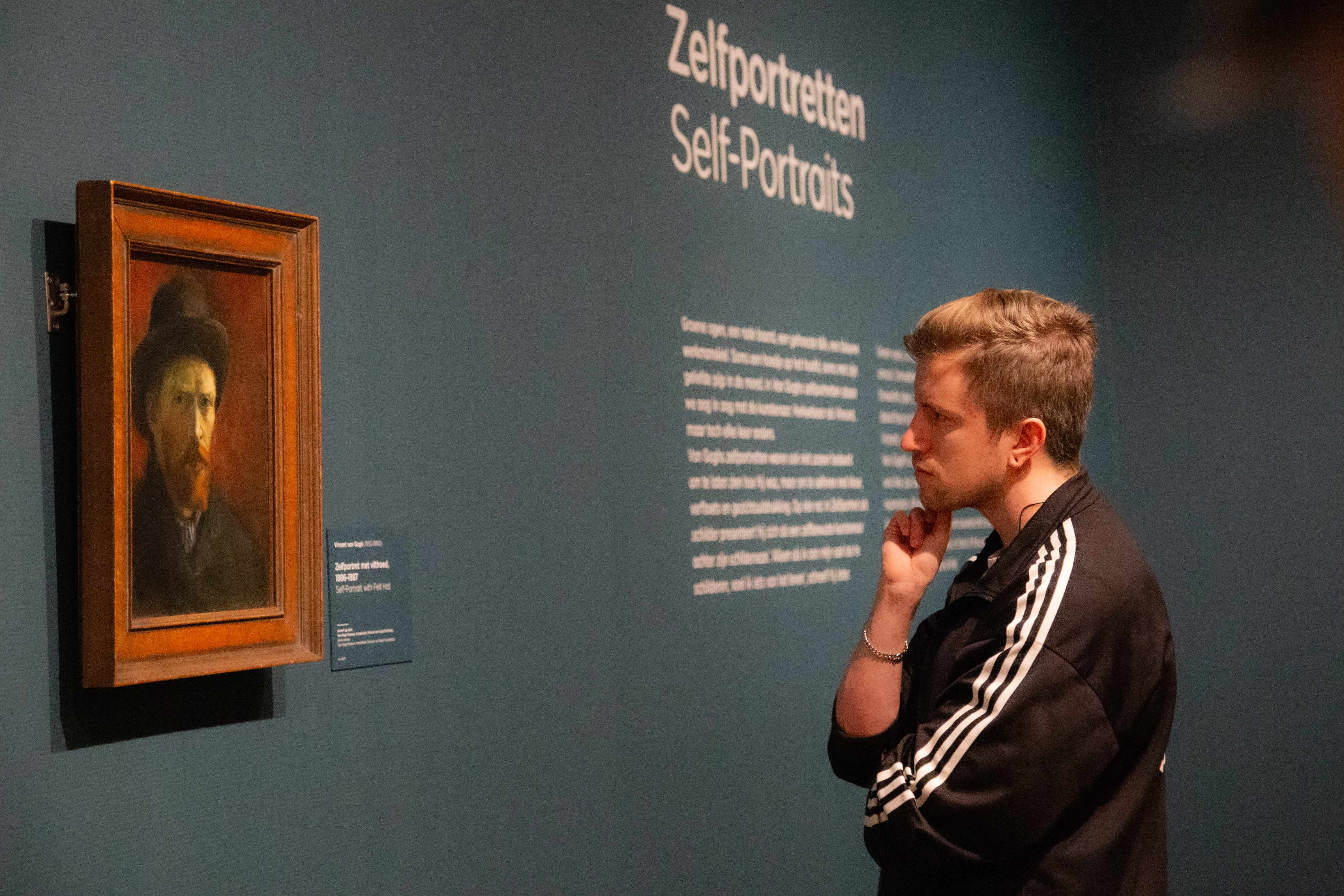 A visitor observes a Van Gogh self-portrait in quiet reflection at the Van Gogh Museum, Amsterdam. Van Gogh Museum, Amsterdam, Netherlands