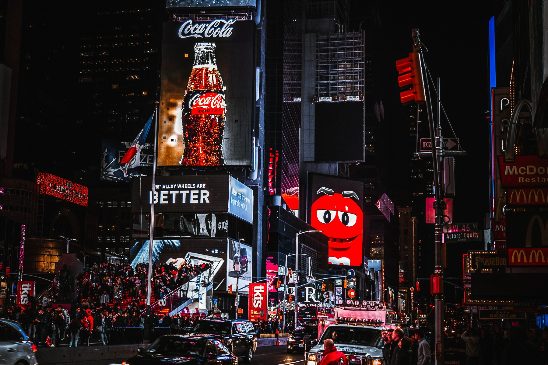 Nighttime shot of Times Square, NYC, filled with bright neon advertisements, billboards, and crowds. New York City, USA