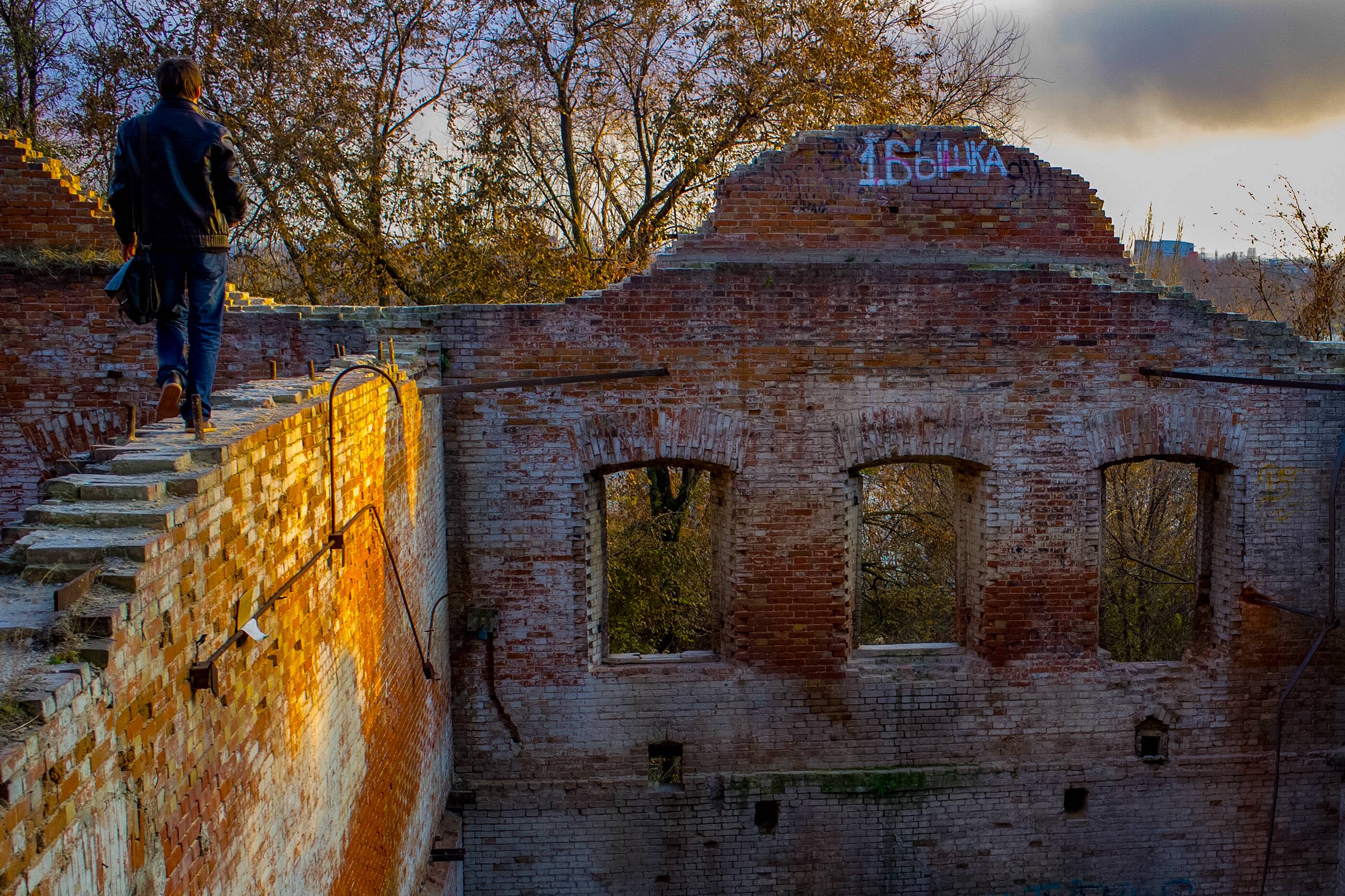 A man walks along the top of an old brick structure, surrounded by the ruins of a historical building. Rostov on Don, Russia