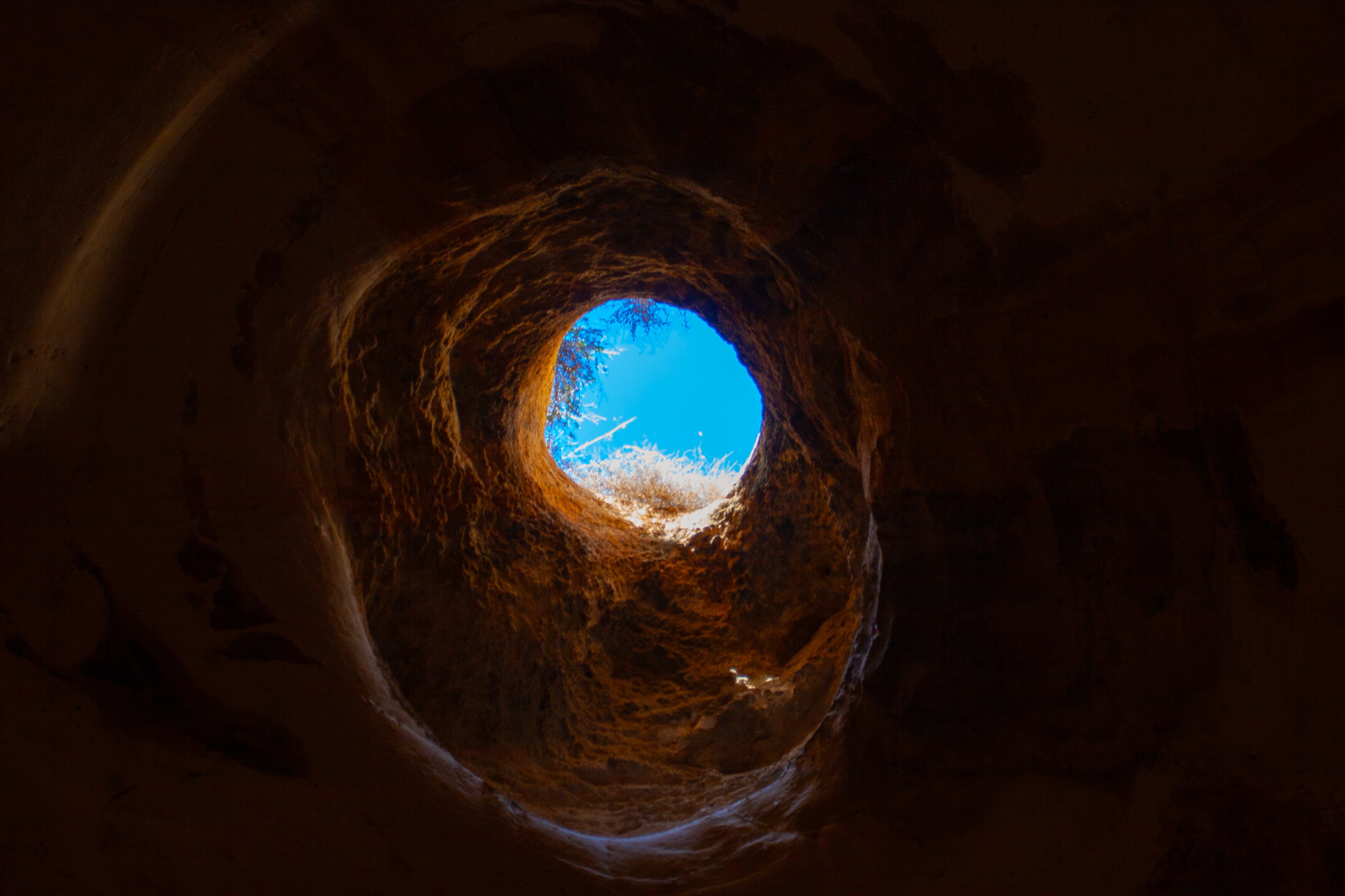 Sunlight streams through a circular opening in a cave ceiling.	. Beit Guvrin, Israel