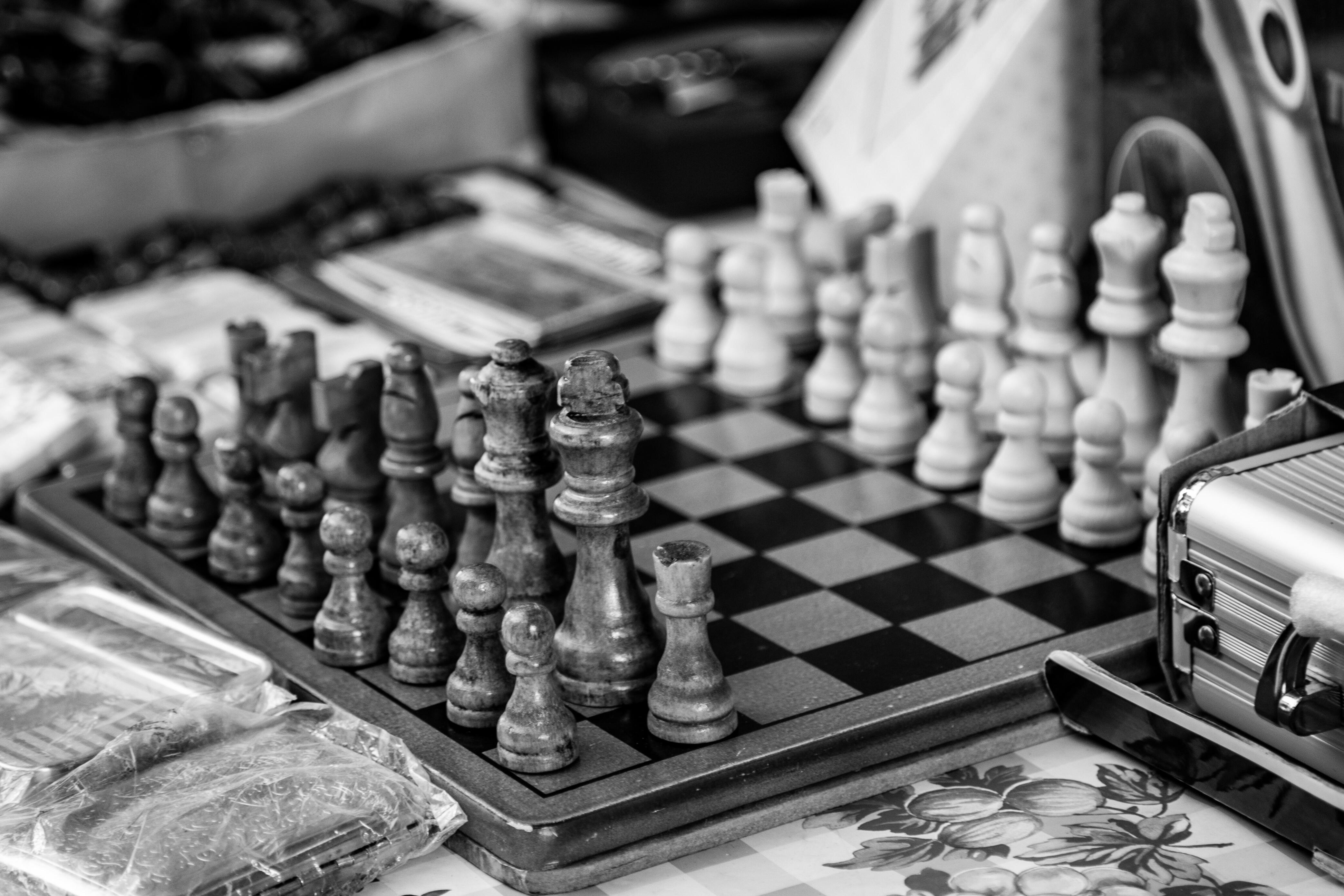 A black and white photo of a vintage wooden chess set, with pieces arranged on a board at a flea market. Flea Market, Jaffo Tel Aviv, Israel