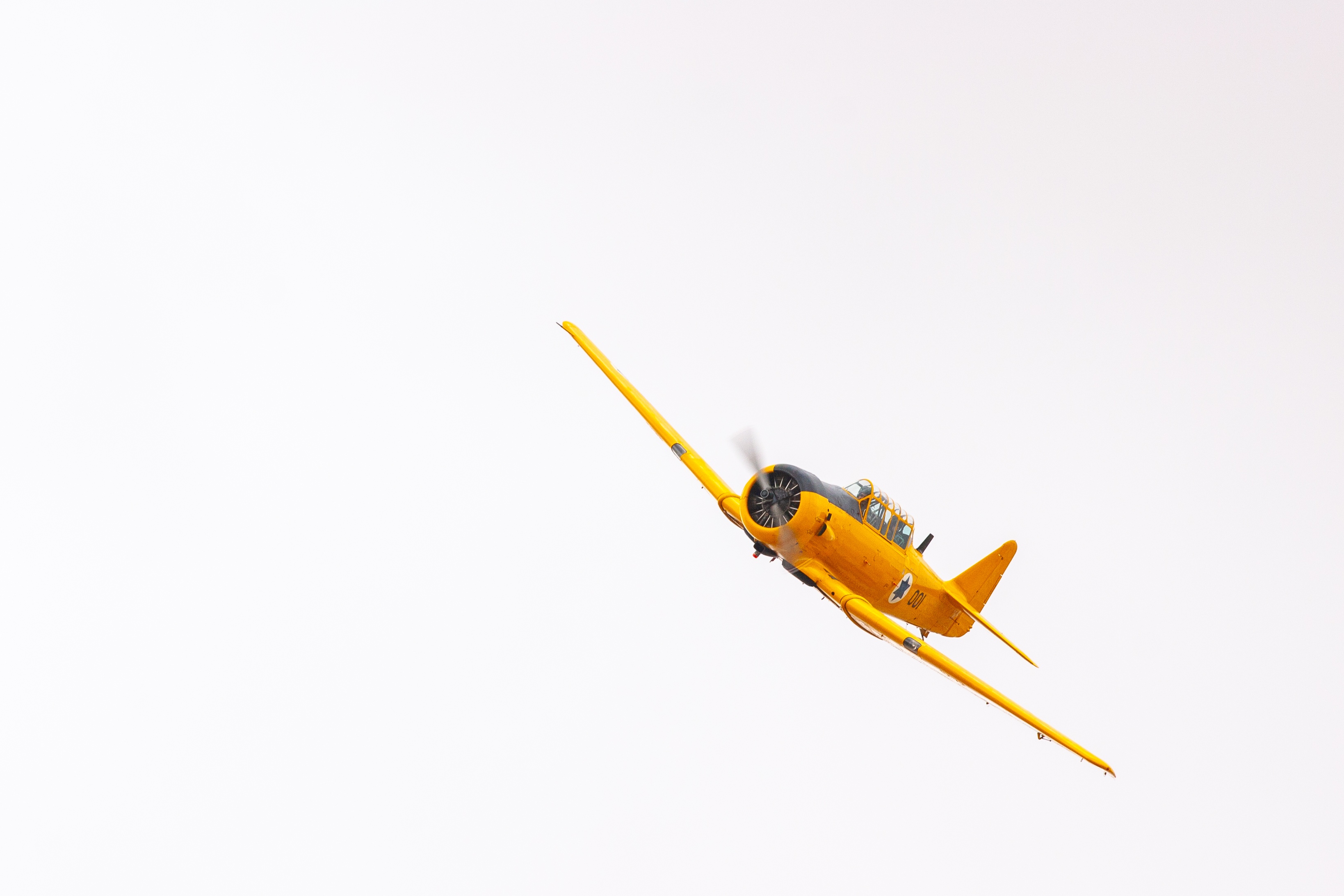 A bright yellow vintage aircraft soaring in the sky during an aerial performance. Air Force Museum, Israel