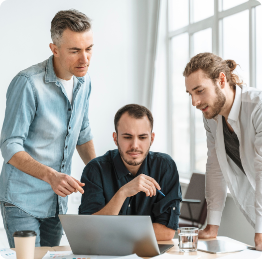 Three people looking at laptop