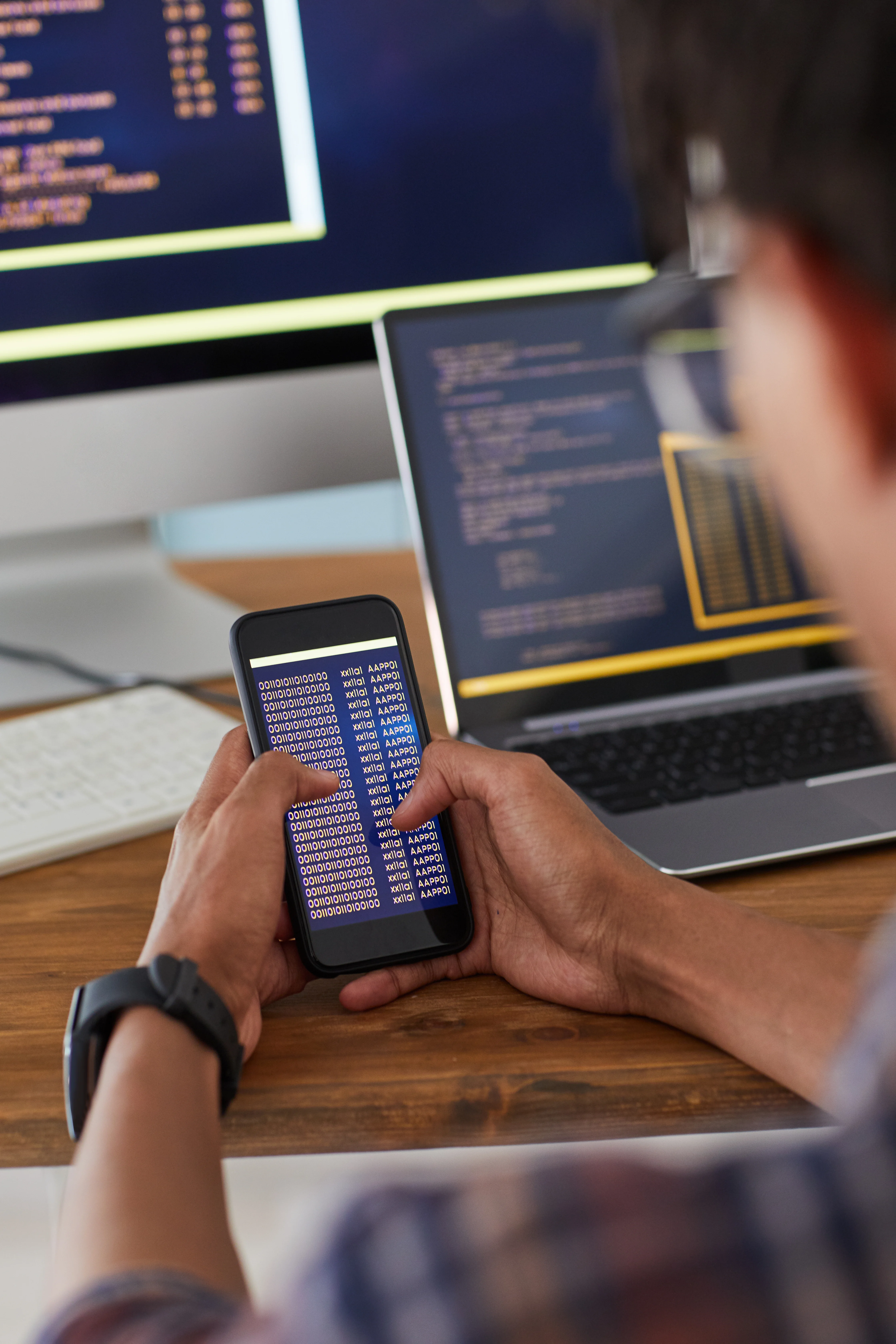 man holding smartphone with code screen
